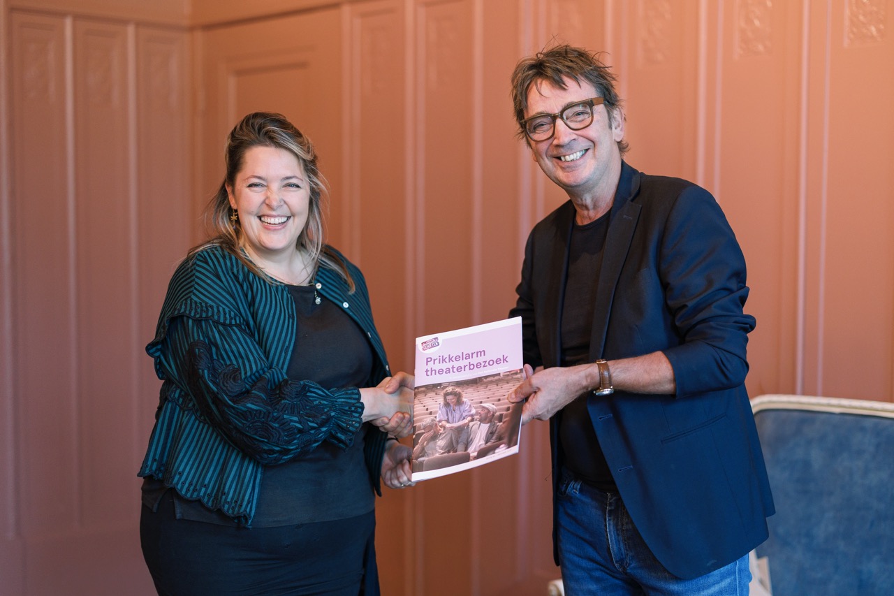 Vier mensen zijn met elkaar in gesprek op een podium